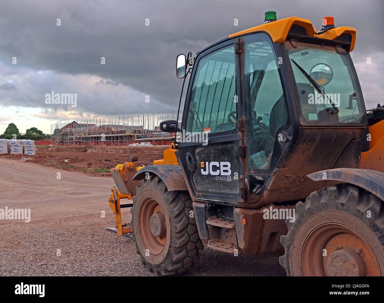 JCB-Fahrzeug mit Stufe V-Motor, auf einer Baustelle, für neue Häuser, Grappenhall Heys, Warrington, Cheshire, England, Großbritannien Stockfoto