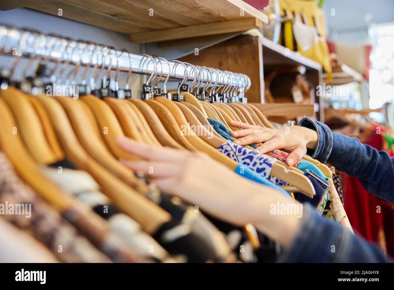 Nahaufnahme Einer Jungen Frau, Die Gebrauchte Nachhaltige Kleidung Aus Dem Second Hand Charity Shop Kauft Stockfoto