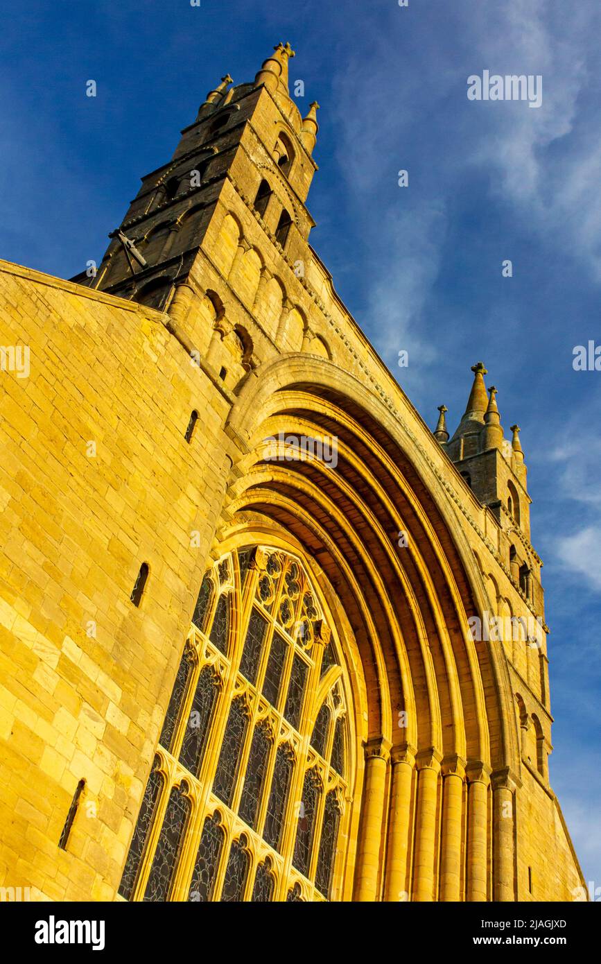 Das Westfenster in der Tewkesbury Abbey ein mittelalterliches Gebäude in Gloucestershire, England, mit blauem Himmel dahinter. Stockfoto