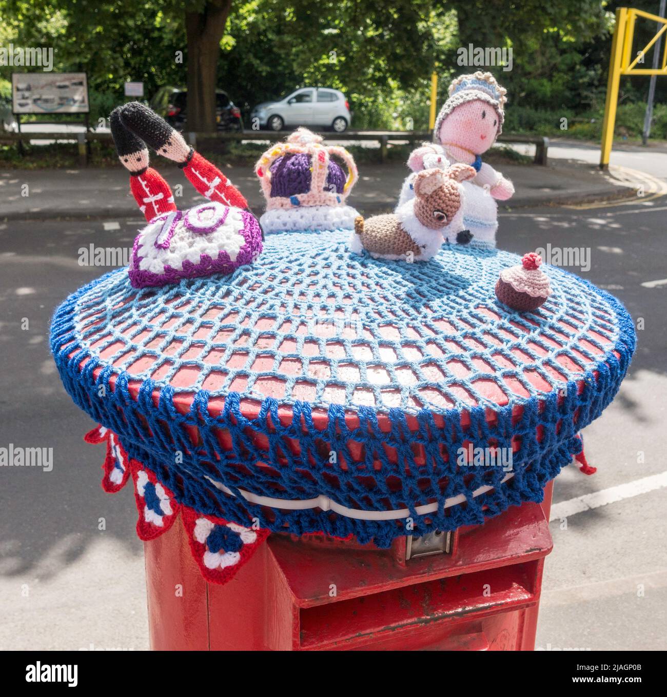 Gestrickte Figuren über einem Briefkasten zur Feier des Platin-Jubiläums von Königin Elizabeth im Jahr 2022 in Heaton Mersey, Greater Manchester, England, Großbritannien Stockfoto
