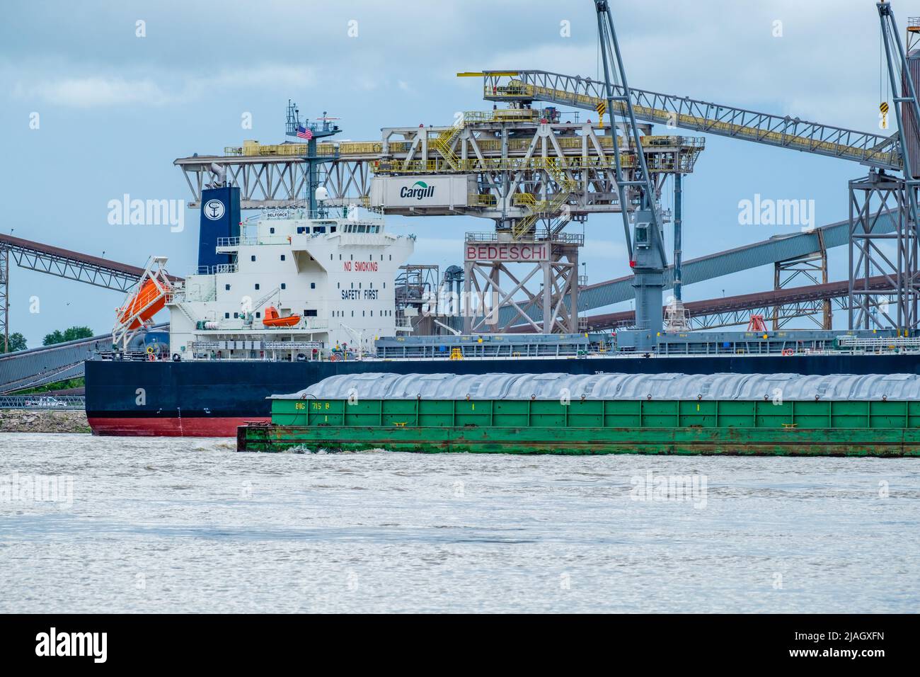 WESTWEGO, LA, USA - 23. MAI 2022: Cargill Getreideaufzug, angedocktes Frachtschiff und vorbeifahrende Barge auf dem Mississippi River in der Nähe von New Orleans Stockfoto