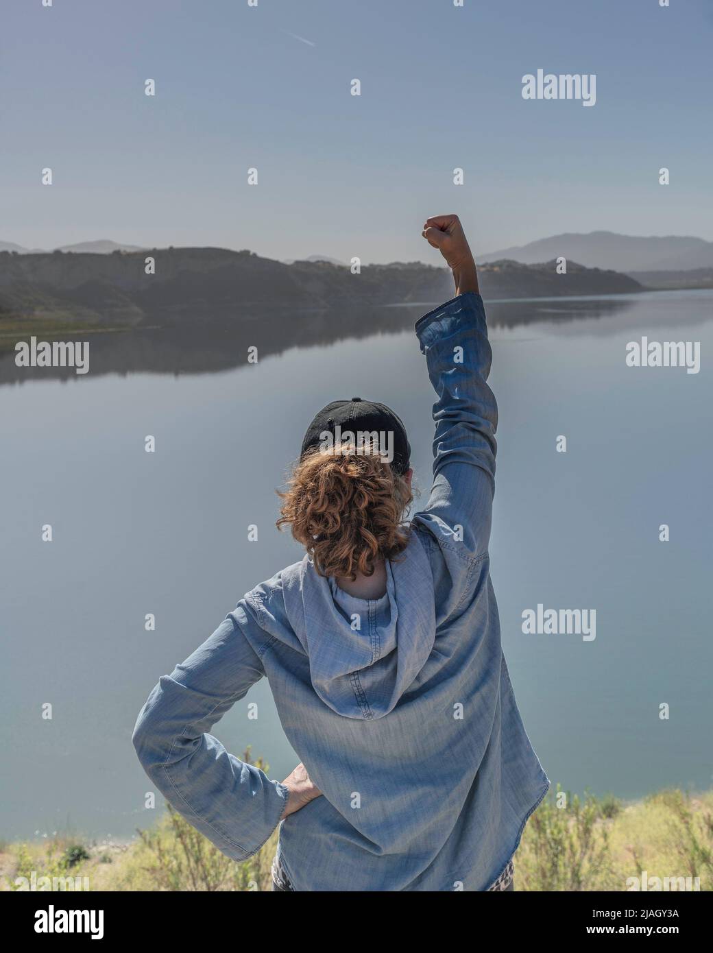 Eine selbstbewusste Frau hebt ihre Faust in die Luft als Beweis der Ermächtigung. Stockfoto