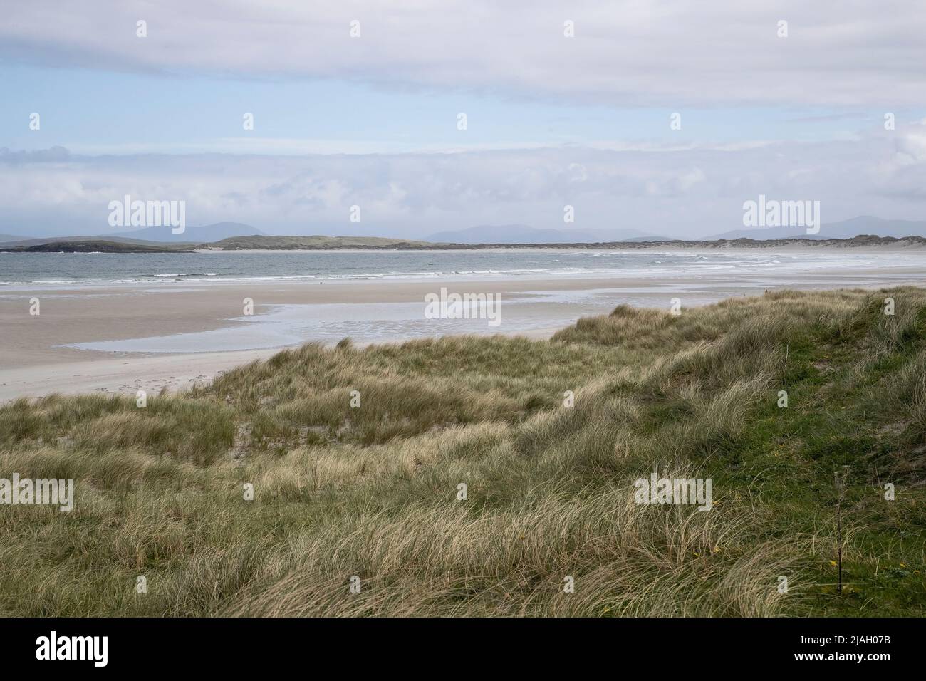 Blick von den Sandhügeln über den weißen Strand und die ankommende Flut nach Vallay Strand bei North Uist in den Äußeren Hebriden Stockfoto