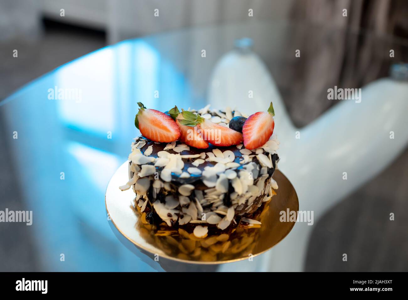 Auf dem Tisch ein Kuchen mit großen Scheiben gehackter Erdbeeren Stockfoto
