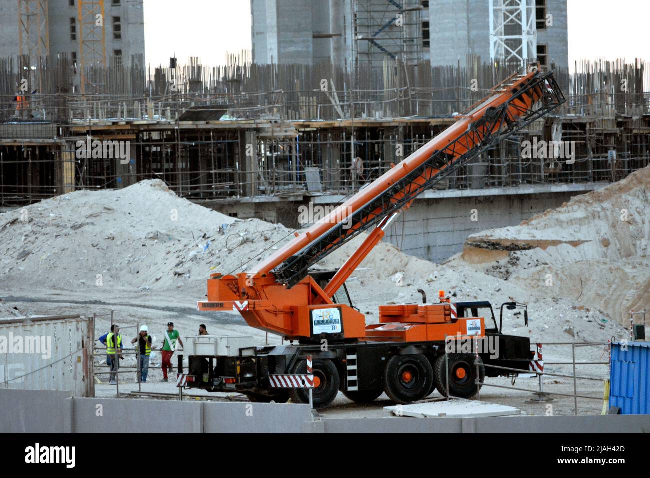 Giza, Ägypten, Mai 23 2022: Ein LKW-Kran auf der Baustelle von Neubauten der Stadt Zed Z mit Arbeitern um sie herum, Sheikh Zayed City, acr Stockfoto