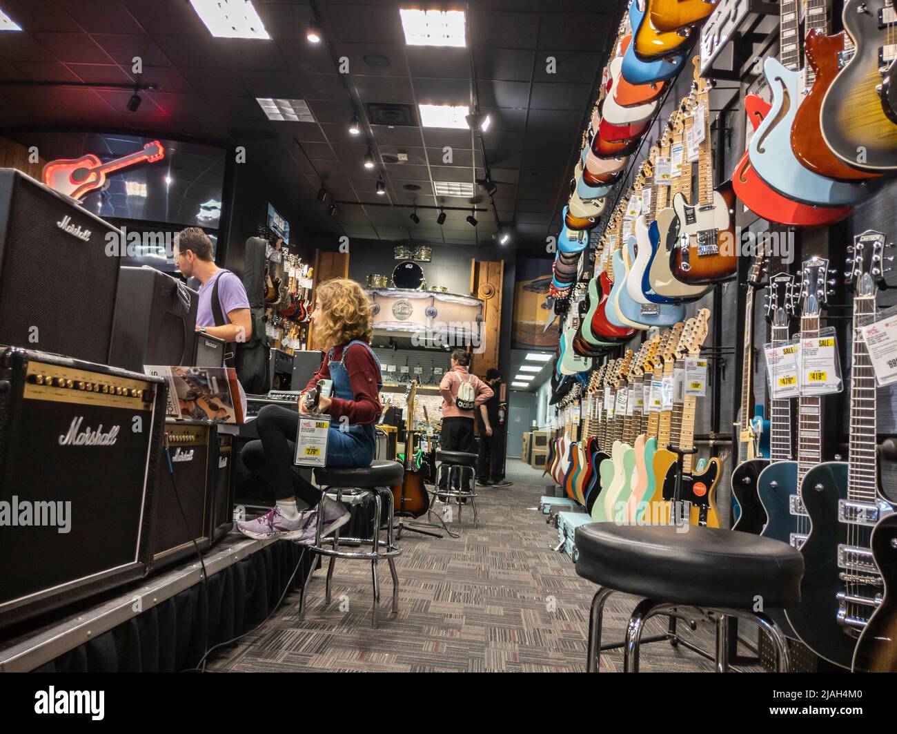 Lynnwood, WA USA - ca. Mai 2022: Ansicht einer Familie, die in einem Guitar Center Gitarren kauft. Stockfoto