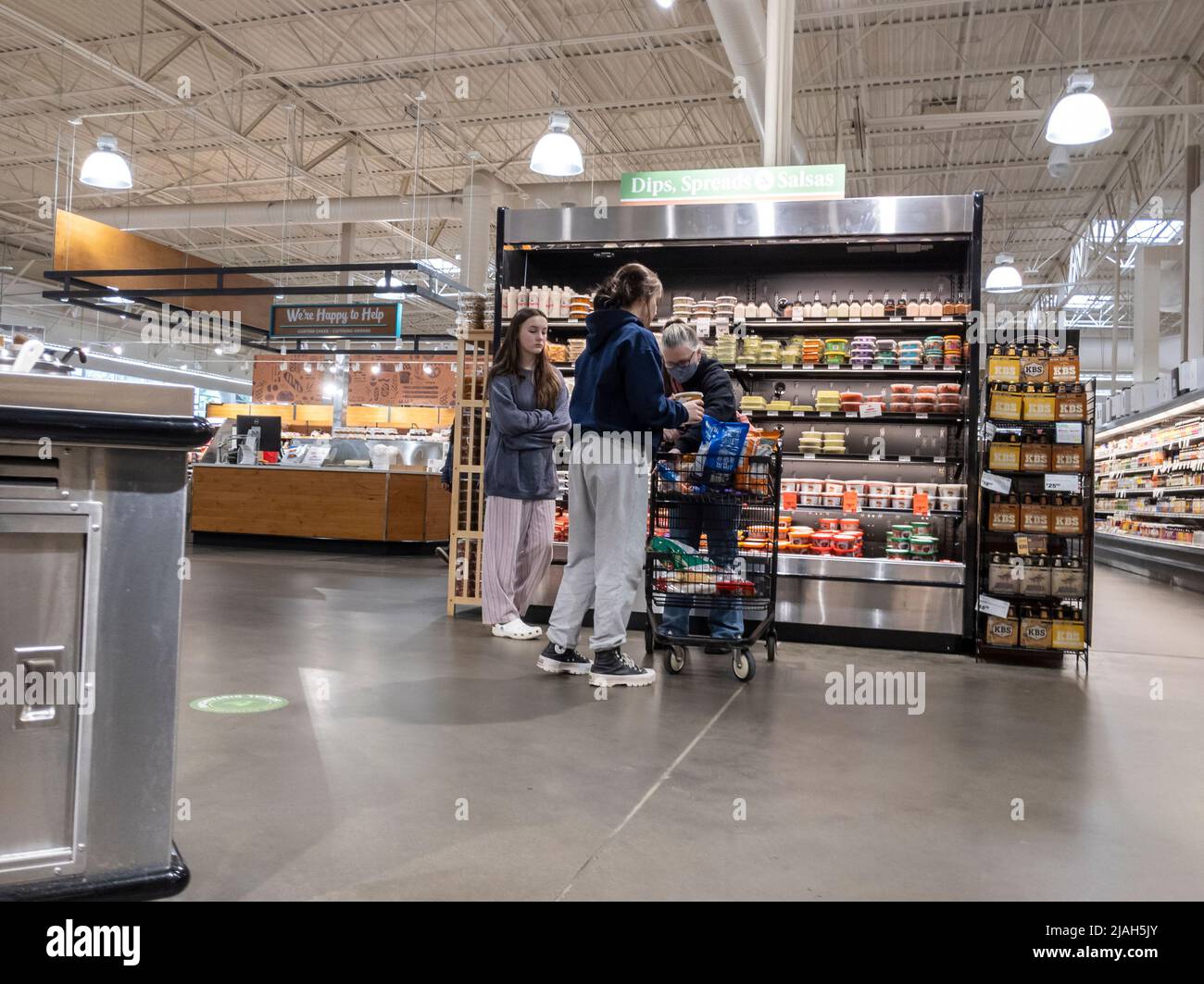 Lynnwood, WA USA - ca. März 2022: Blick auf einen Familieneinkauf rund um den Hummus und Salsa Endcap in einem Stadt- und Landmarkt. Stockfoto