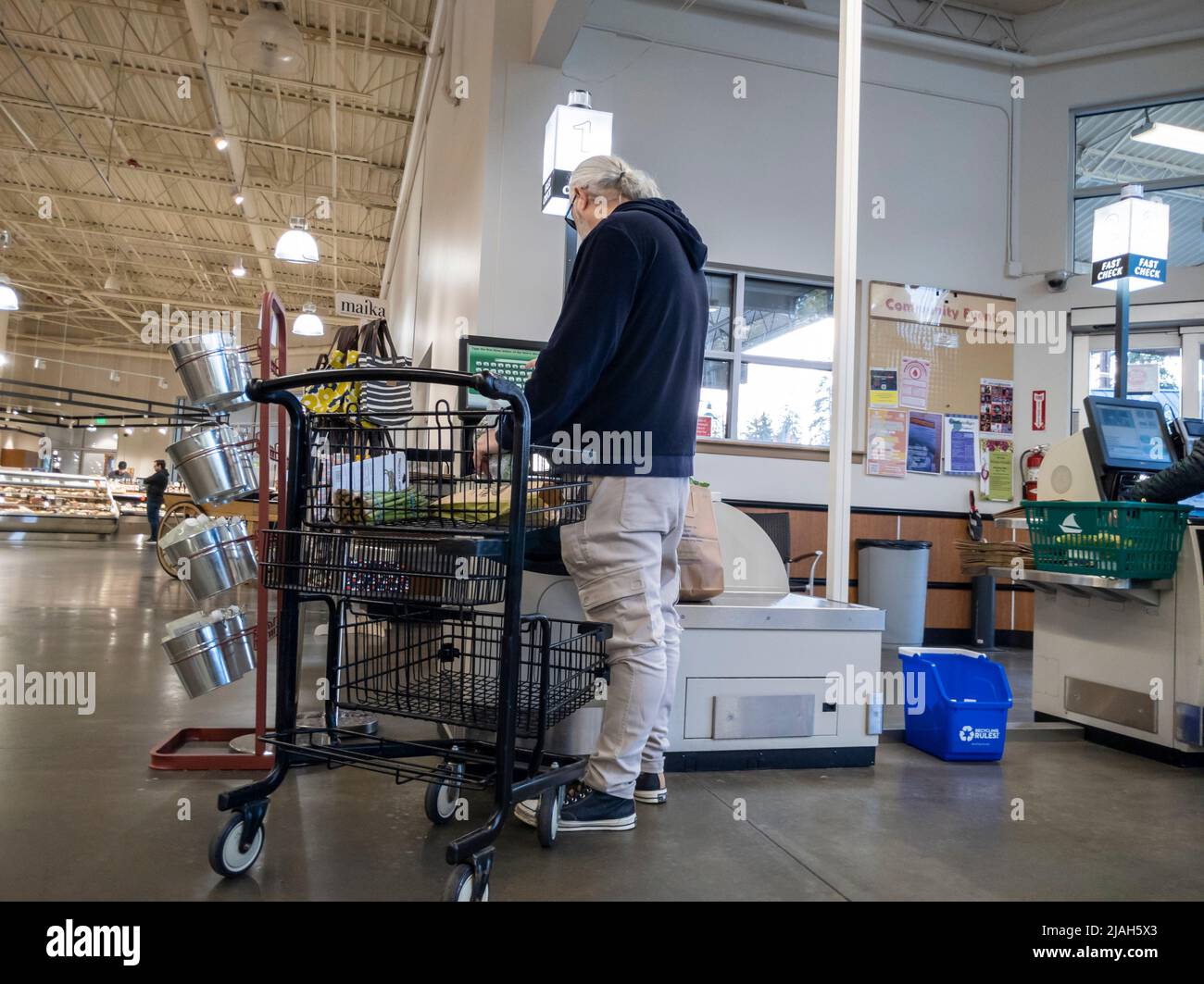 Mill Creek, WA USA - ca. Mai 2022: Blick auf einen älteren Mann, der seine Lebensmittel an der Selbstabmeldung im Town and Country Market auscheckte. Stockfoto