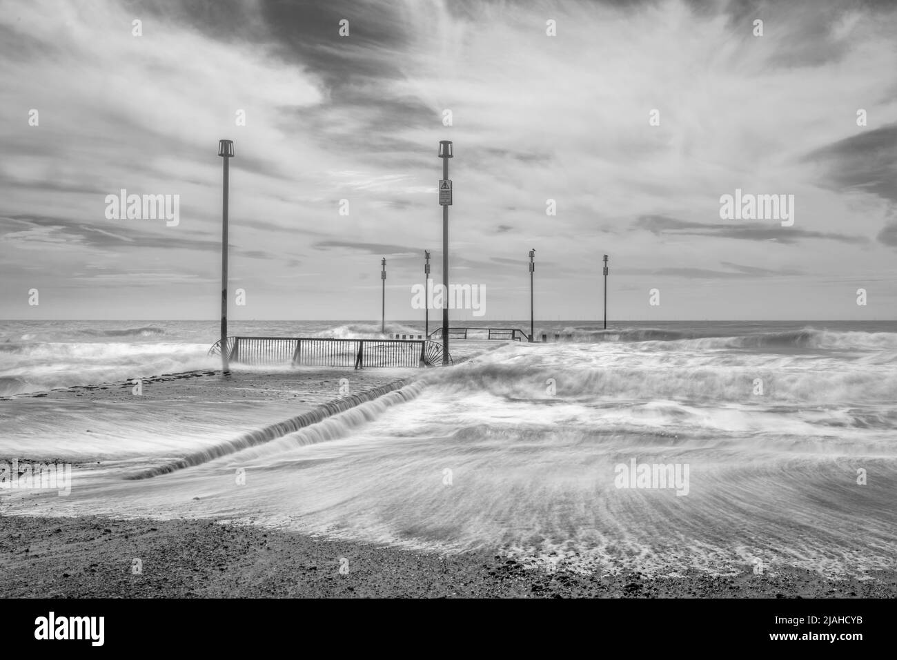 Wellen, die über ein Abflussrohr mit Markierungsstiften krachen Stockfoto