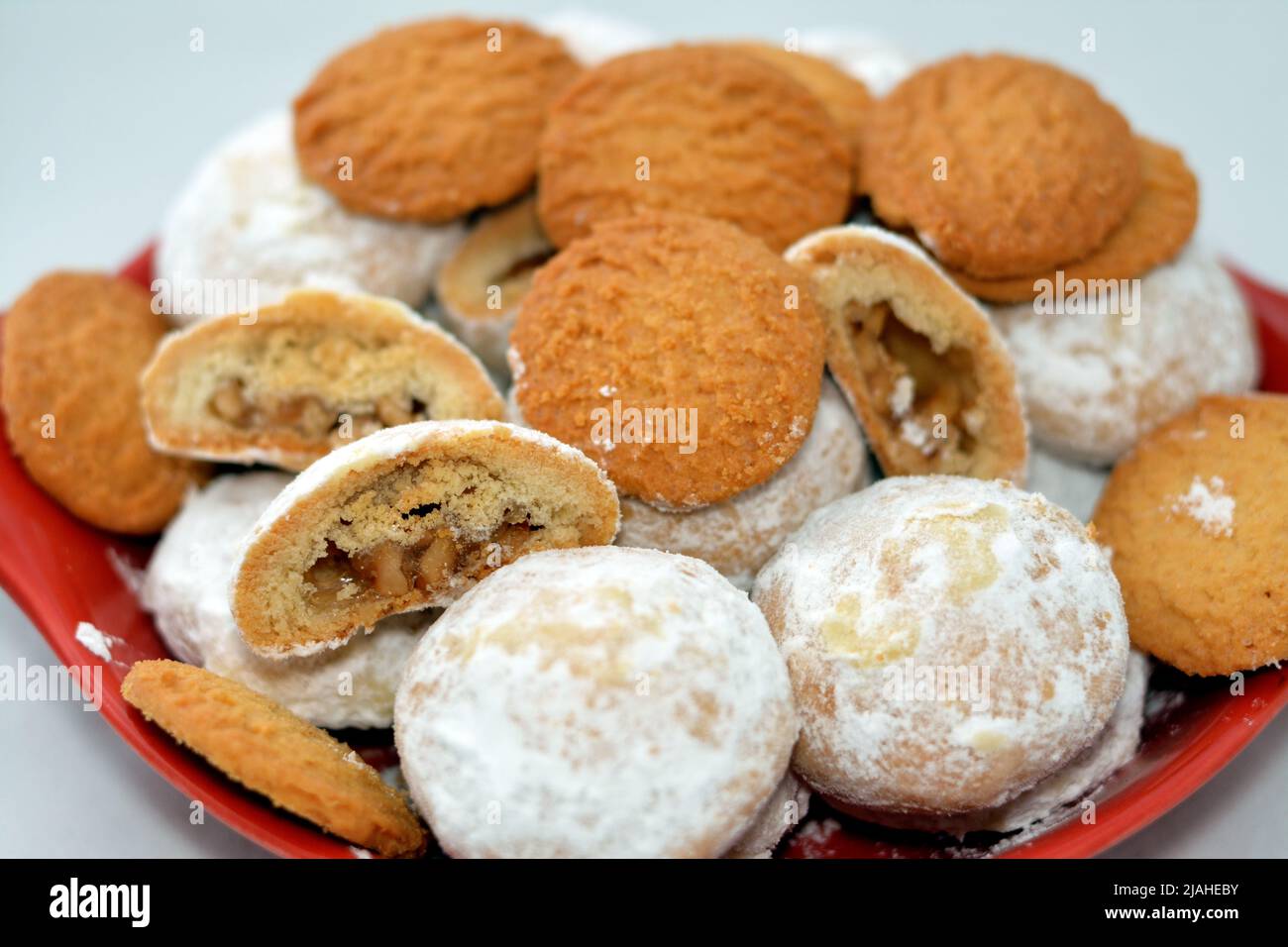 Traditionelle arabische Kekse zur Feier der islamischen Feiertage des El-Fitr-Festes, ägyptische Kekse mit zerkleinerten Kokosnüssen und Kahk mit Pulver bedeckt Stockfoto