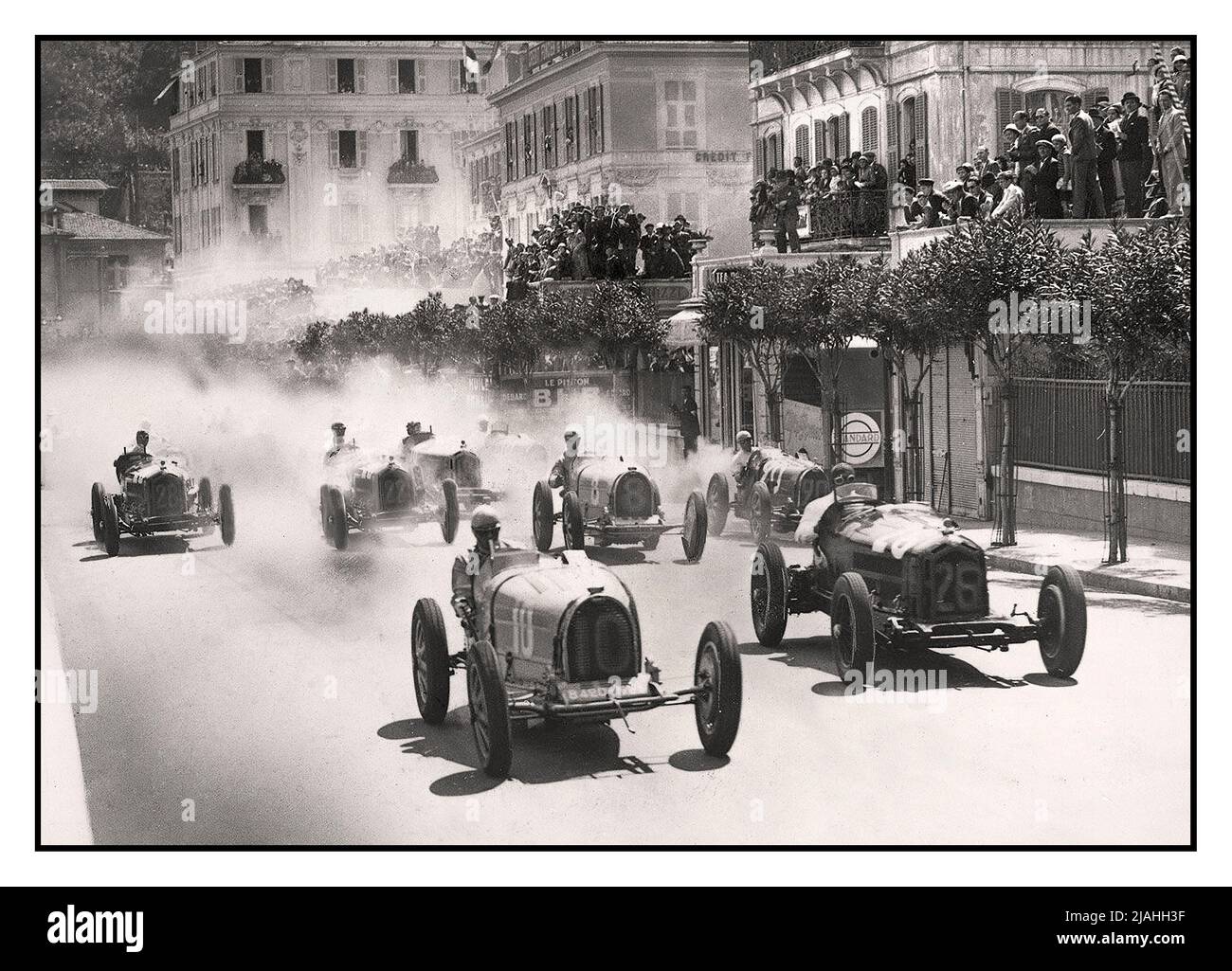 Monaco Grand Prix Grid Start 1933 SIEGER Achille Varzi (Nr. 10) im Vordergrund war der erste mit einem Bugatti. Der Grand Prix von Monaco 1933 war ein Grand Prix-Rennen, das am 23. April 1933 auf dem Circuit de Monaco ausgetragen wurde. Dies war der erste Grand Prix, bei dem die Rasterpositionen nach der Übungszeit und nicht nach der etablierten Methode des Ballings entschieden wurden. Achille Varzi und Tazio Nuvolari tauschten während des Rennens mehrmals die Führung aus und das Rennen wurde in der letzten Runde zu Varzi zugunsten ausgerechnet, als Nuvolaris Wagen wegen Überdrehung in Brand geriet. Stockfoto