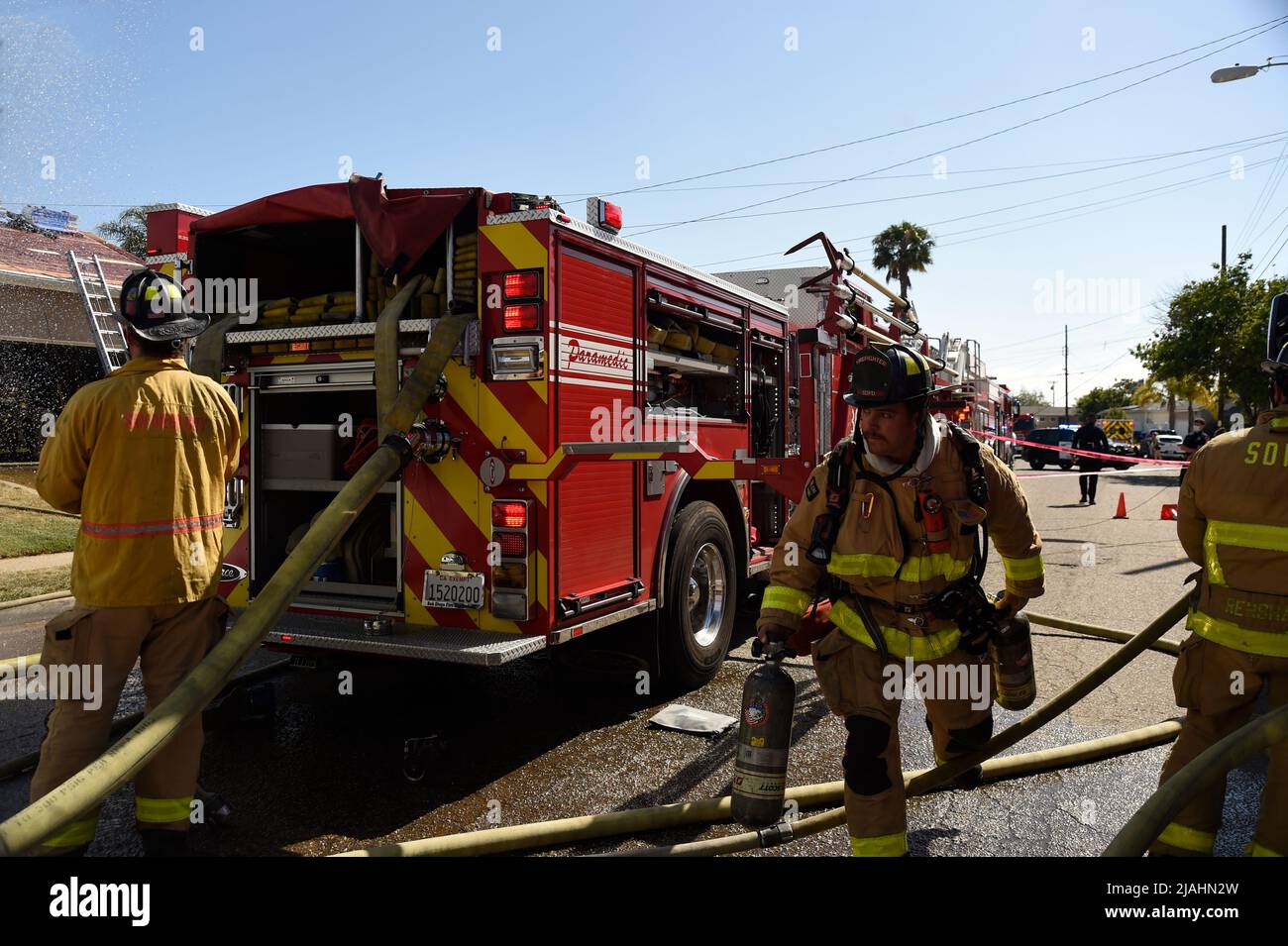 SDFD Feuerwehrmann bewegt sich in Richtung des Feuers mit Luftflaschen für Auffüllung Stockfoto