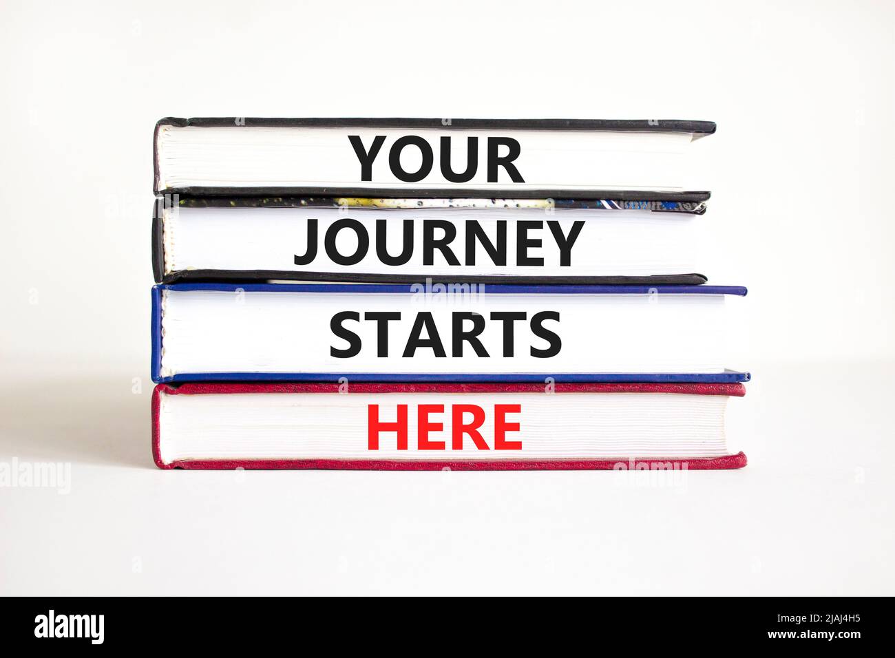 Ihre Reise beginnt hier Symbol. Concept Words Ihre Reise beginnt hier auf Büchern auf einem schönen weißen Tisch weißen Hintergrund. Geschäft, Motivation A Stockfoto