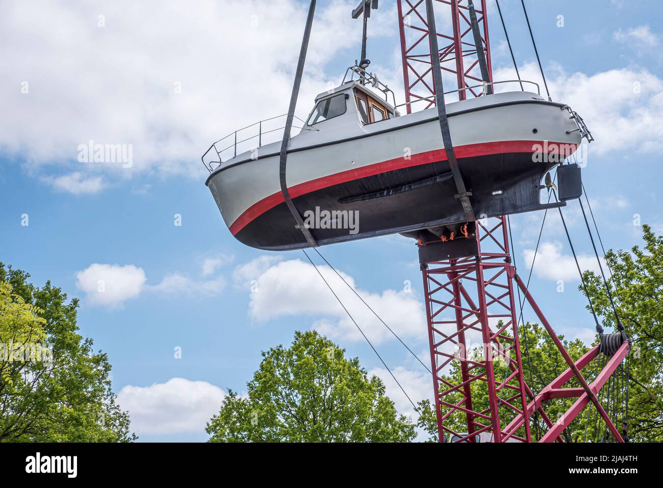 Ein Motorboot mit einem Kran über die Baumwipfel heben, Kopenhagen, 25. Mai 2021 Stockfoto