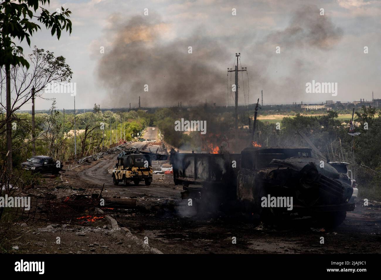 Lysytschansk, Ukraine. 28.. Mai 2022. An der Brücke zwischen Severodoonetsk und Lysytschansk, Luhansk, ist ein zerstörter Lastwagen in Brand zu sehen. Während russische Truppen die Offensive aus verschiedenen Richtungen starten und hoffen, ukrainische Vorräte und Verstärkungen abzuschneiden und die volle Kontrolle über das Gebiet Luhansk zu erlangen, wird die Stadt Lyschansk, die Severodoonetsk verbindet, schwer bombardiert und belagert. (Foto von Alex Chan Tsz Yuk/SOPA Images/Sipa USA) Quelle: SIPA USA/Alamy Live News Stockfoto