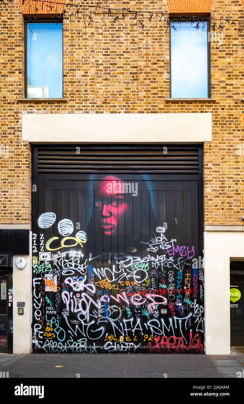 Street Art und Grafitti an einem Garagentor in Brick Lane, London, Großbritannien Stockfoto
