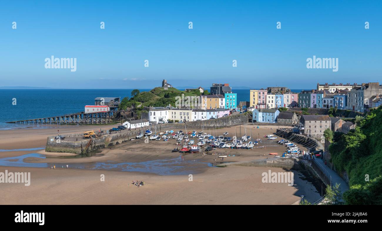 Der hübsche Hafen von Tenby Pembrokeshire mit seinen vielen kleinen Booten, die von dem farbenfrohen Reihenhaus auf der umliegenden Klippe überragt werden Stockfoto