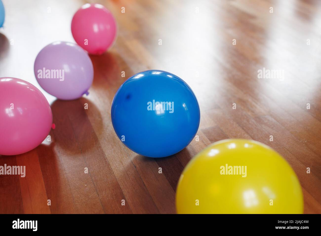 Bunte Luftballons auf einem Holzboden Stockfoto