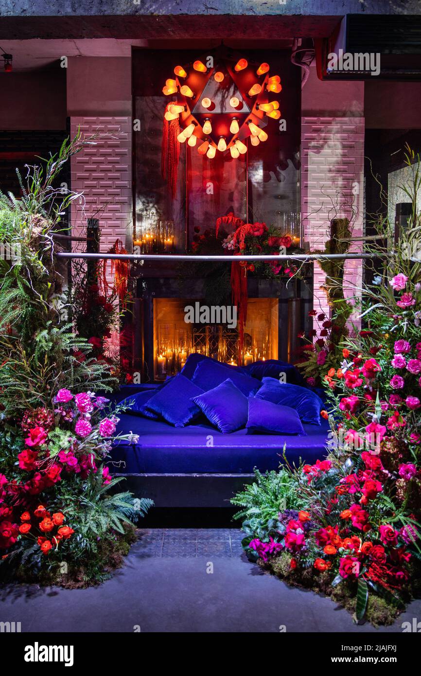 Bett mit Kamin mit Blumen und Kerzen dekoriert. Stockfoto