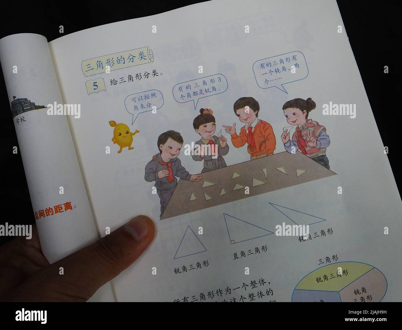 YICHANG, CHINA - 31. MAI 2022 - Ein Bürger zeigt die Illustrationen des zweiten Bandes des veröffentlichten Mathe-Lehrbuchs der vierten Klasse für Grundschulen Stockfoto
