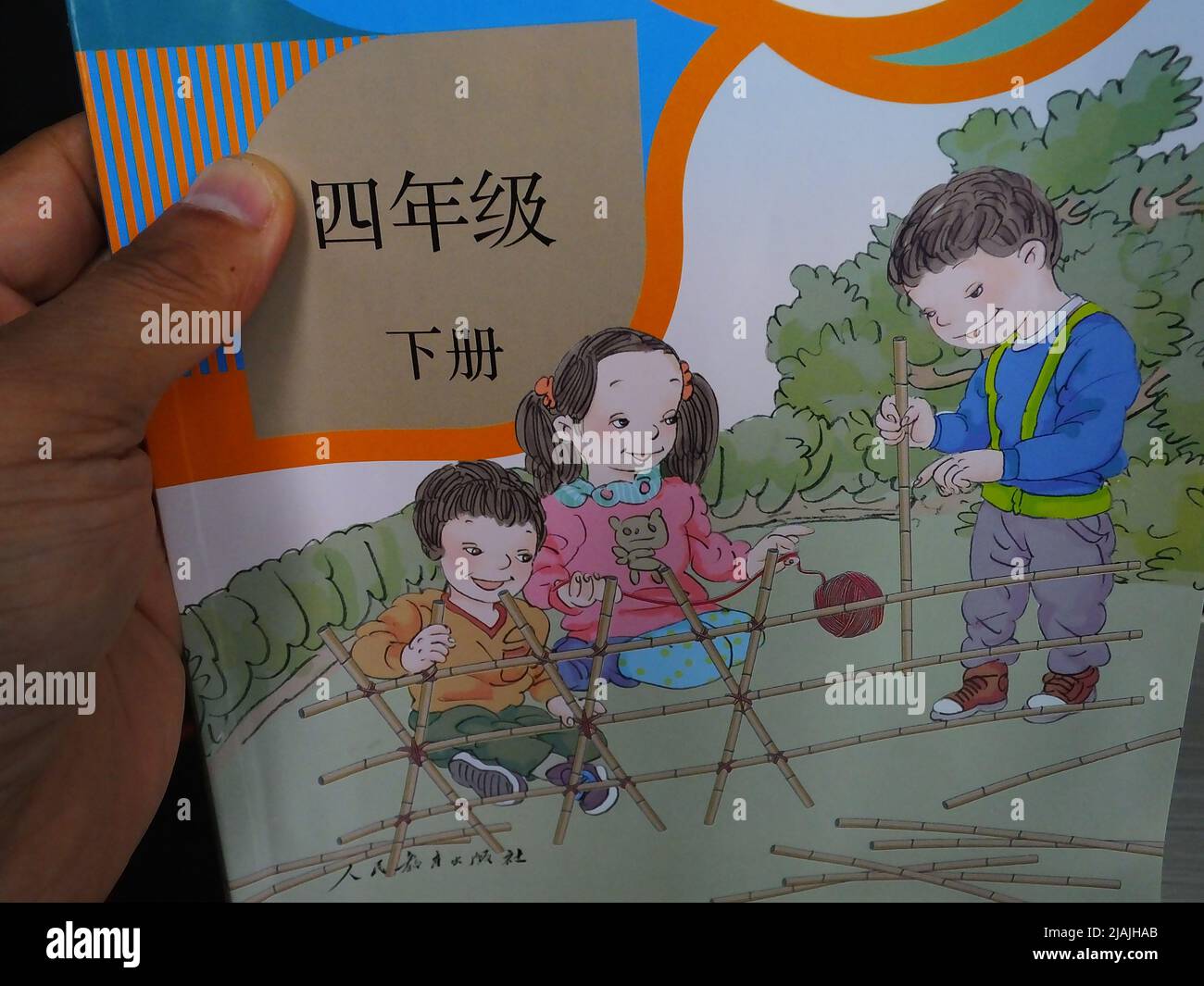 YICHANG, CHINA - 31. MAI 2022 - Ein Bürger zeigt die Illustrationen des zweiten Bandes des veröffentlichten Mathe-Lehrbuchs der vierten Klasse für Grundschulen Stockfoto