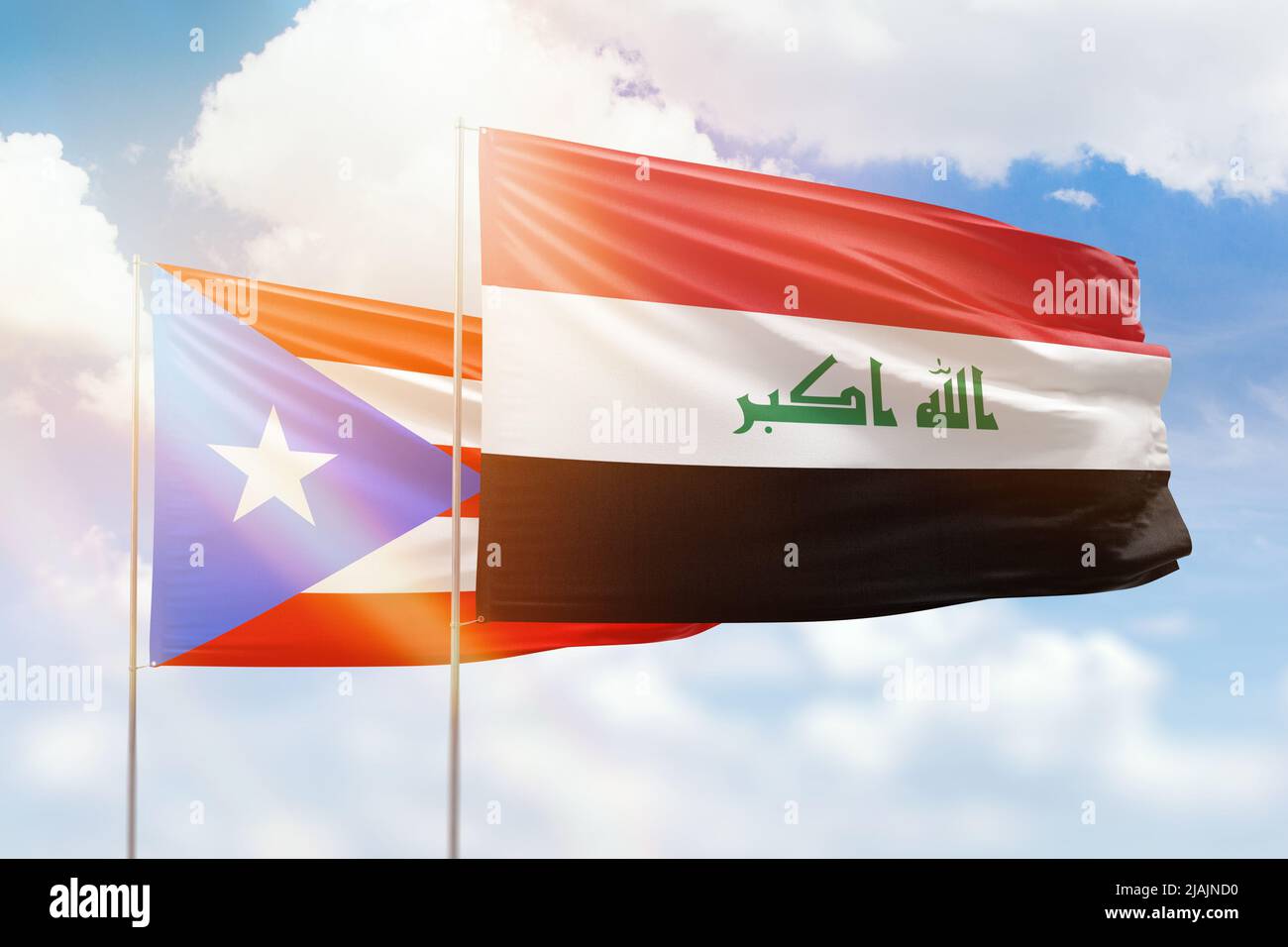 Sonniger blauer Himmel und Flaggen von irak und puerto rico Stockfoto