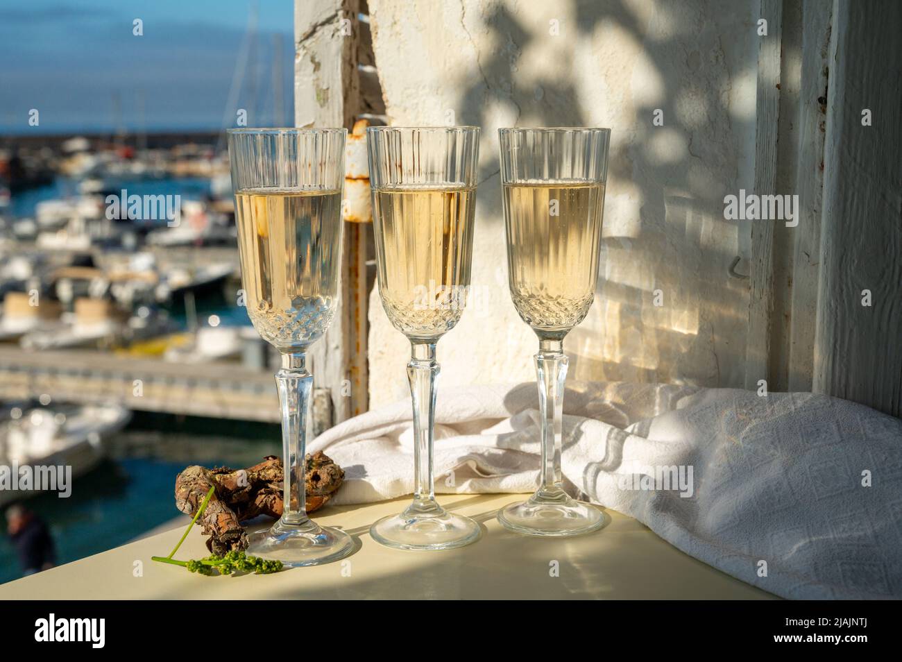 Drei Gläser französischer Champagner Sekt und Blick auf bunte Fischerboote im alten Hafen von Cassis, Provence, Frankreich, Sommerfest in PR Stockfoto
