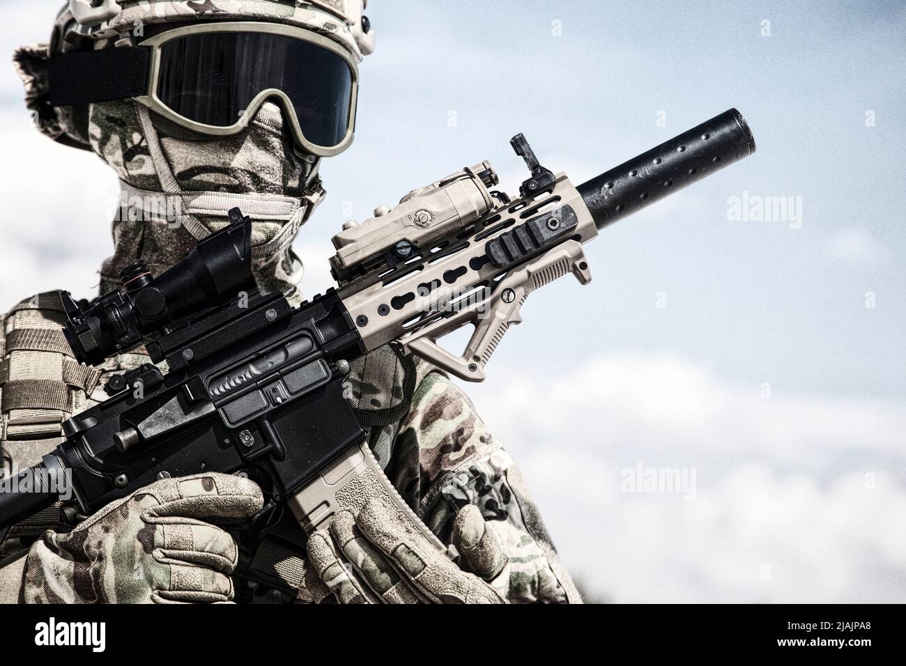 Halblanges Porträt eines Soldaten, der mit einer Schusswaffe in den Händen posiert. Stockfoto