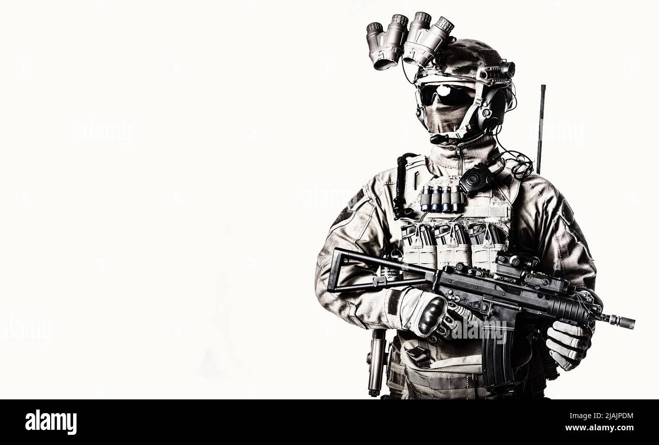 Studioaufnahme eines Militäranmannes, der mit Nachtsichtgerät, Radio-Headset und Kurzrohr-Gewehr ausgestattet ist. Stockfoto