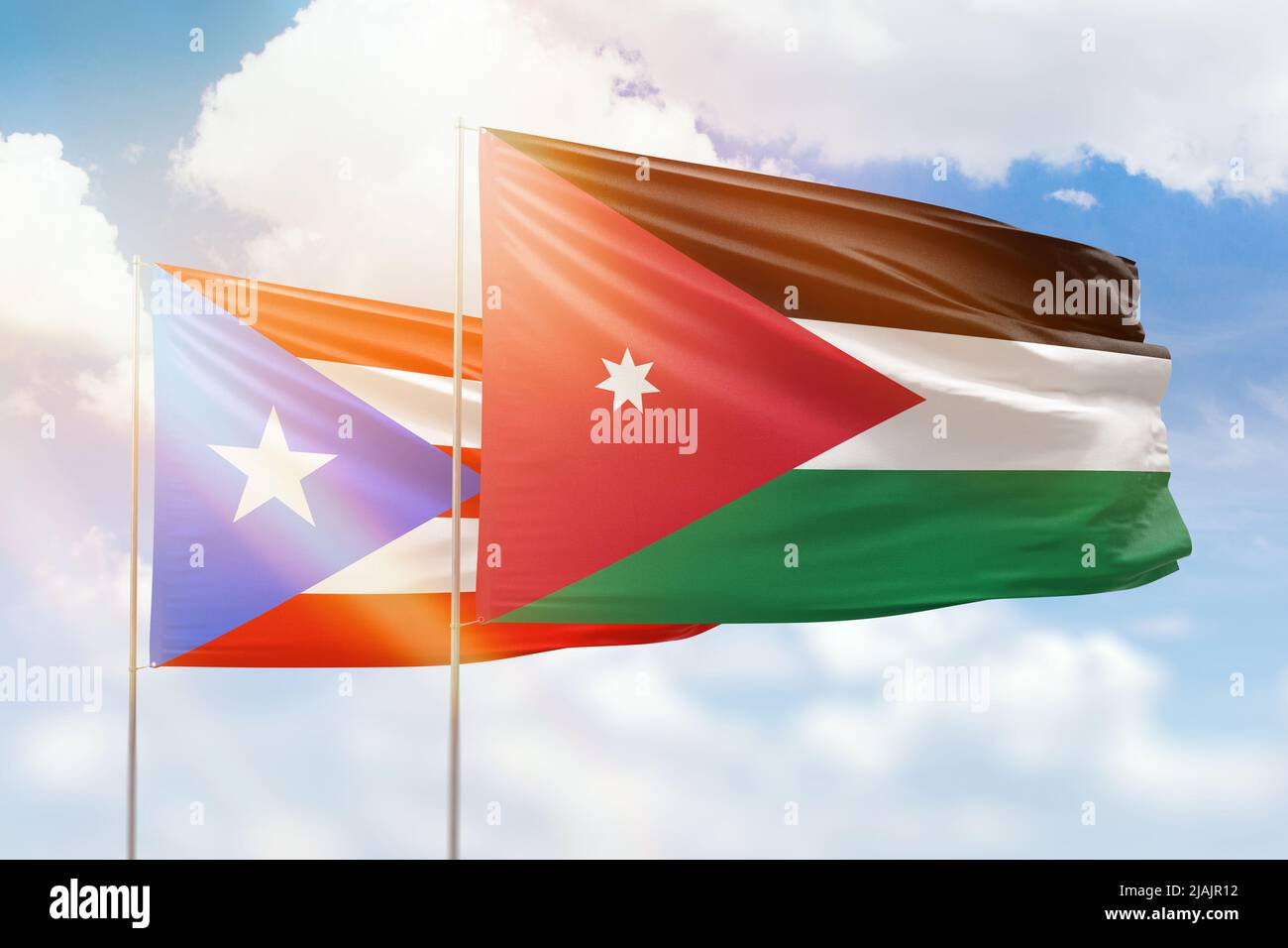 Sonniger blauer Himmel und Flaggen von jordanien und puerto rico Stockfoto