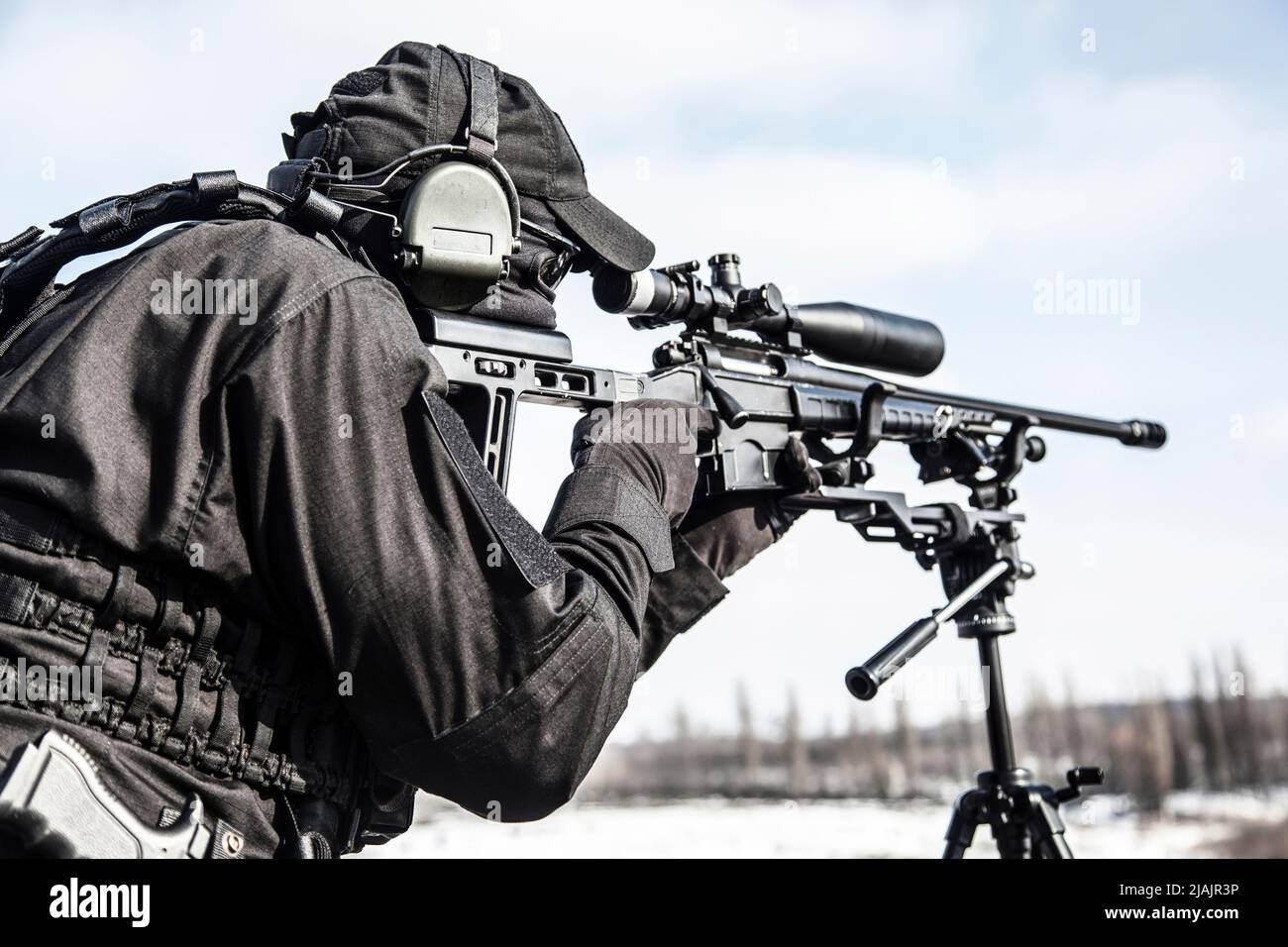 Scharfschütze mit teleskopischer optischer Sicht auf Scharfschützengewehr, das auf einem Stativ montiert ist. Stockfoto