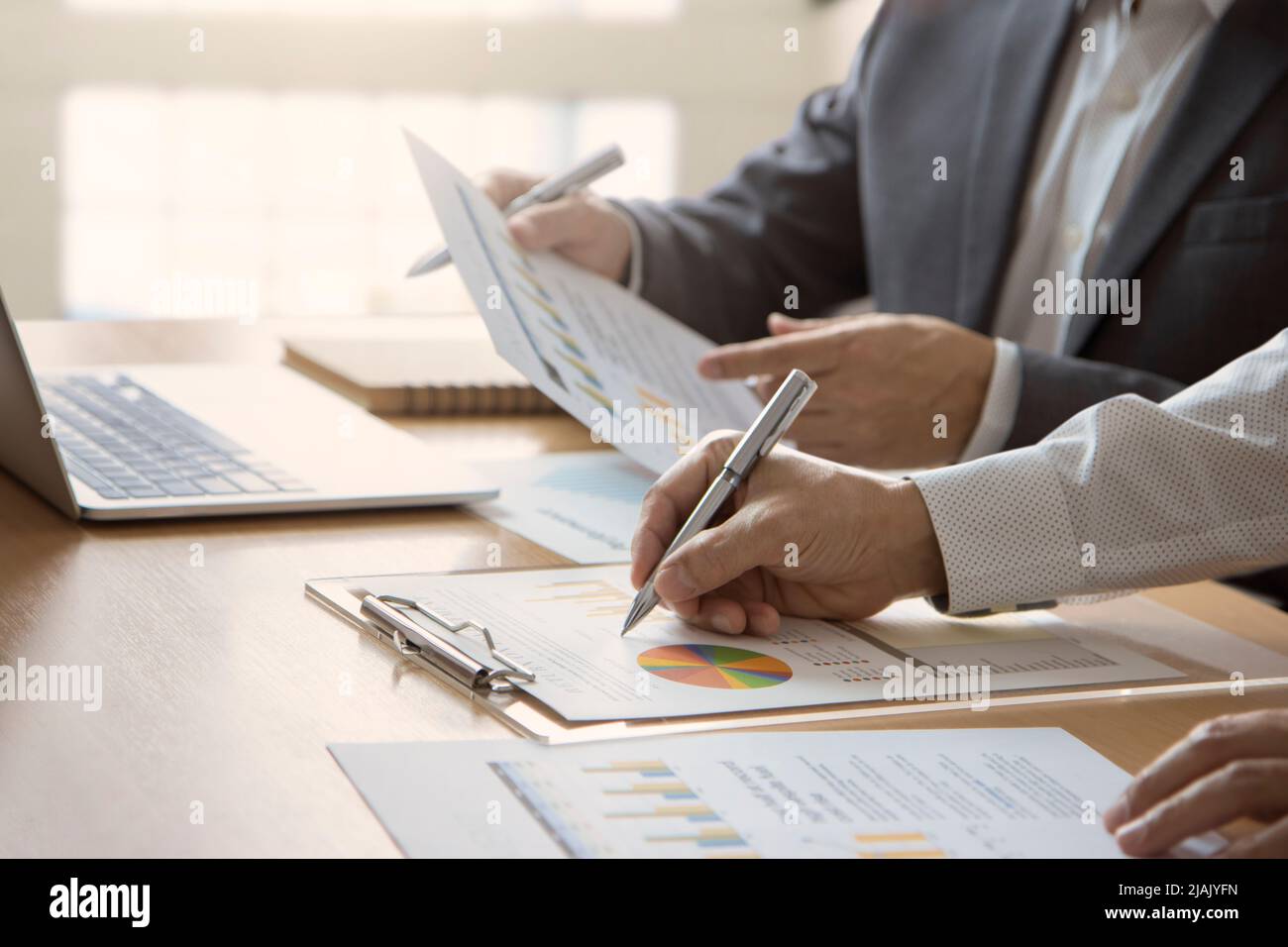 Geschäftsleute oder Analysten mit Laptop-Computer, die Geschäftsinformationen über den Return on Investment überprüfen Stockfoto