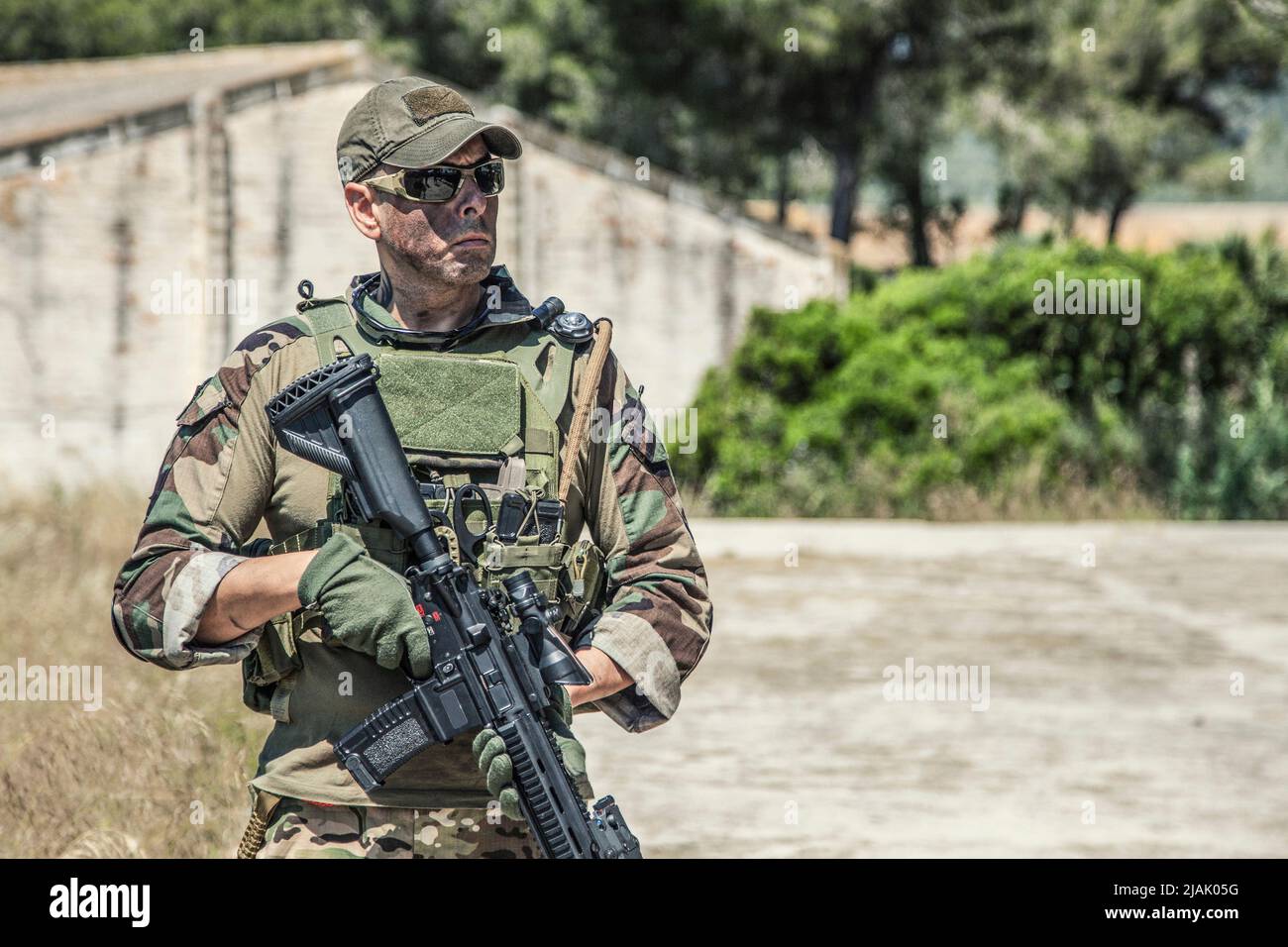 Halblanges Porträt eines bewaffneten Navy-Robben-Kämpfers mit ballistischer Brille, während er im Freien steht. Stockfoto