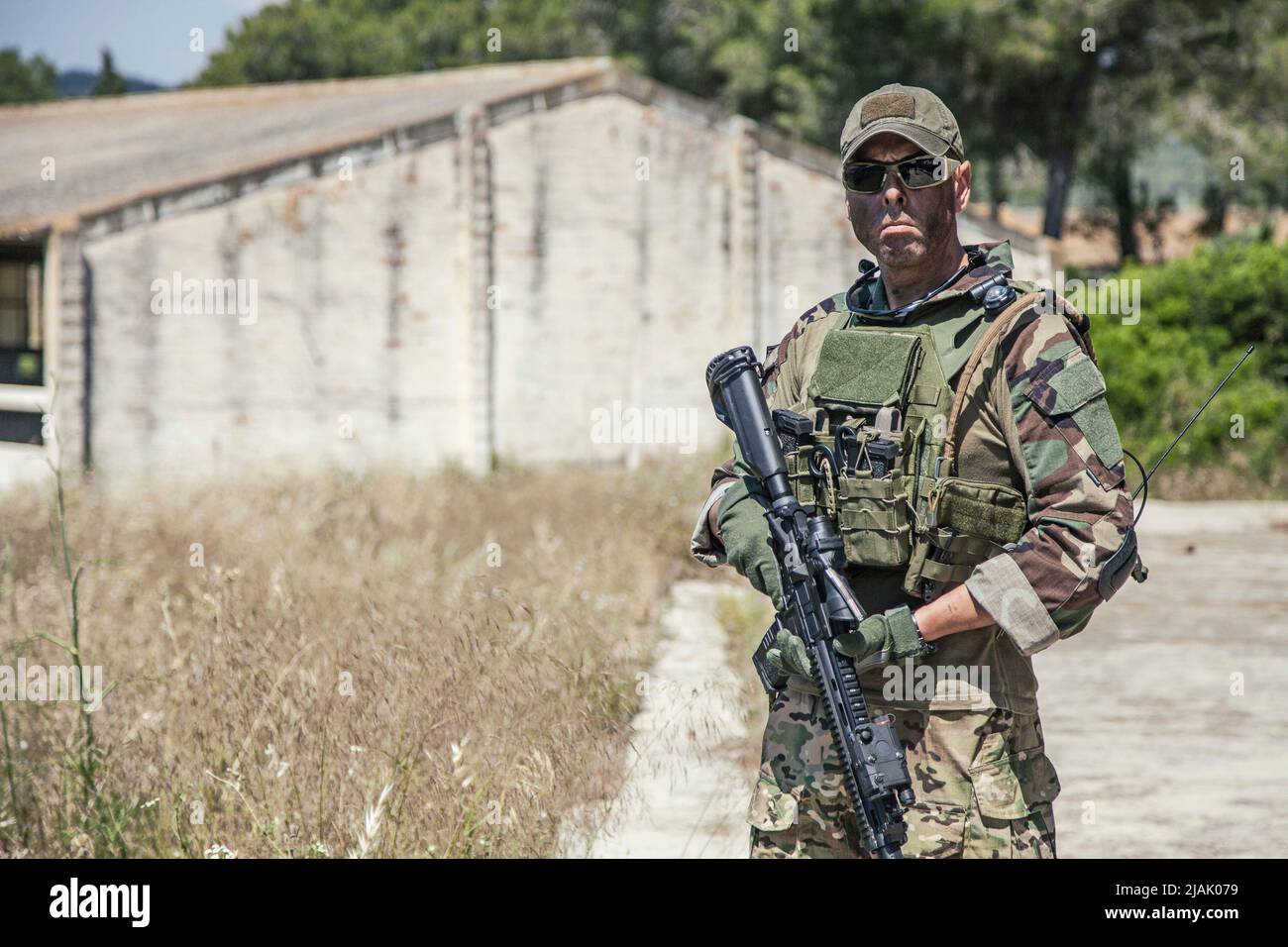 Halblanges Porträt eines bewaffneten Navy-Robben-Kämpfers mit ballistischer Brille, während er im Freien steht. Stockfoto