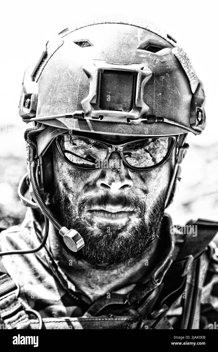 Moderner Kampfkämpfer, der während einer Mission in ein taktisches Radio-Headset spricht. Stockfoto