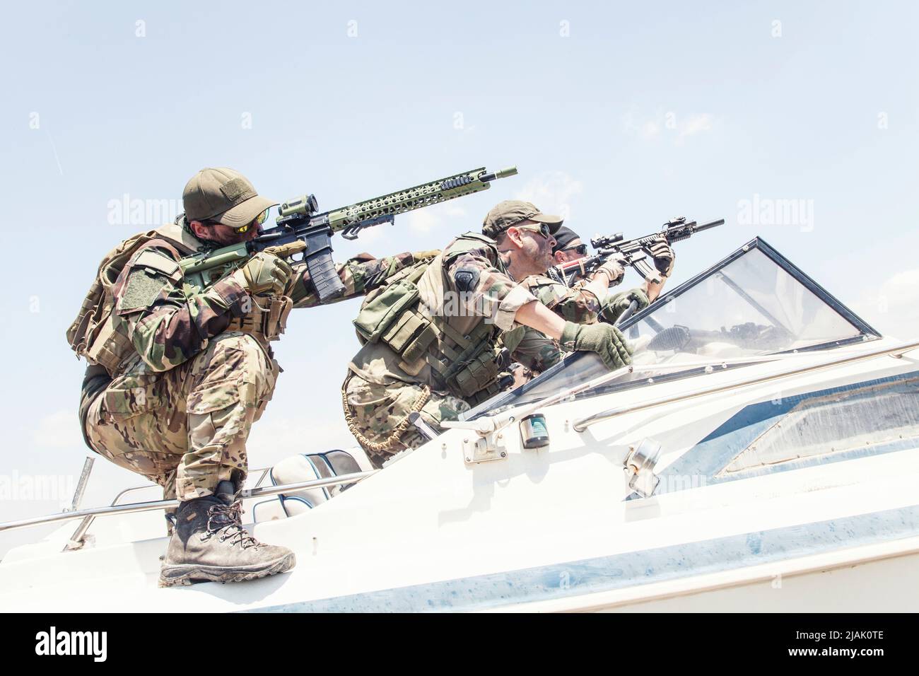 Bewaffnete Navy-Robben greifen ihren Feind an, während sie auf einem Boot sitzen. Stockfoto