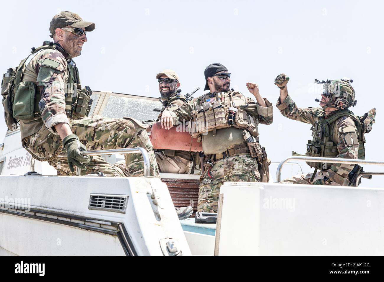 Navy Robben feiern eine erfolgreiche Mission mit Kameraden auf einem Schnellboot. Stockfoto