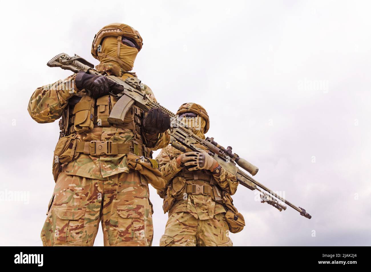 Bewaffnete und bewaffnete Soldaten der Spezialeinheiten mit Gewehren, Blick aus der unteren Perspektive. Stockfoto