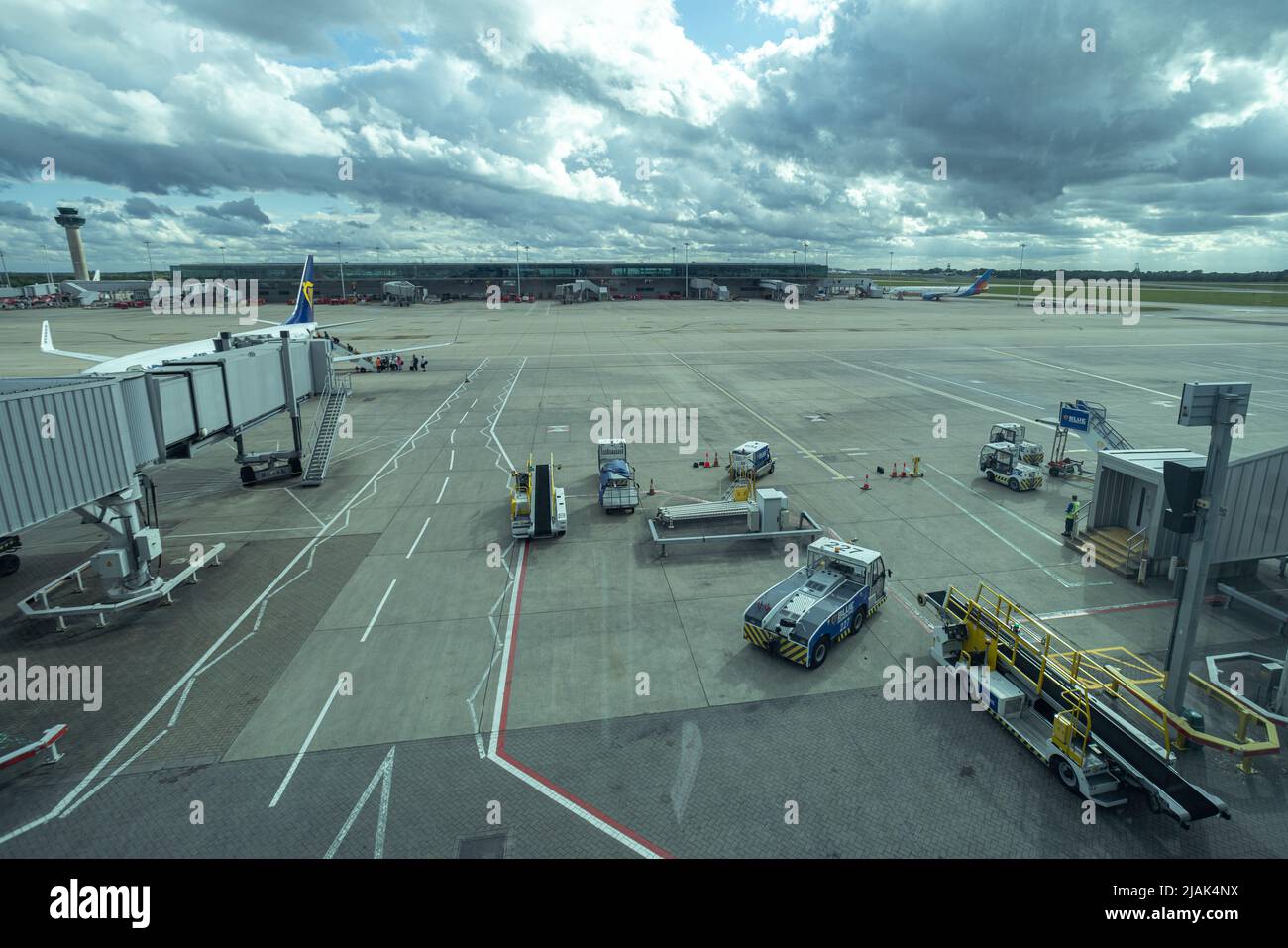 Asphalt am Flughafen London Stansted mit Förderbändern für Gepäckfahrzeuge Stockfoto