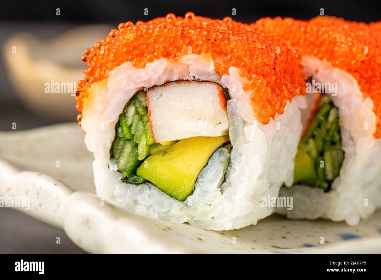 Sushi-Set mit verschiedenen Produkten auf einem schwarzen Steinteller Stockfoto