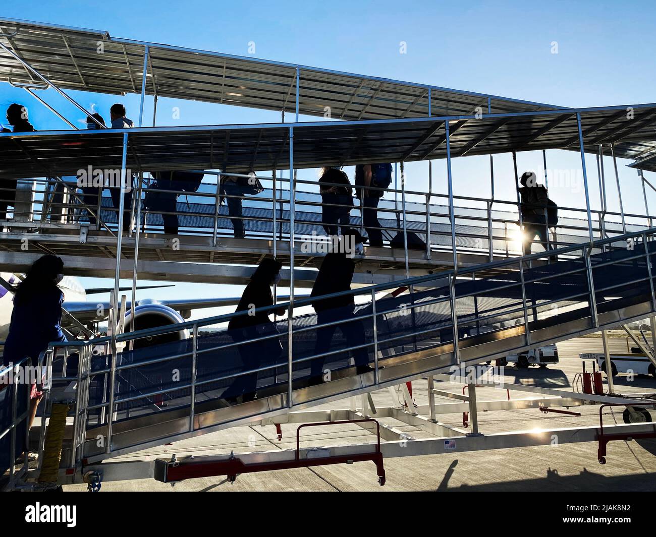 Passagiere, die auf einer Jetbrücke in ein Flugzeug steigen Stockfoto