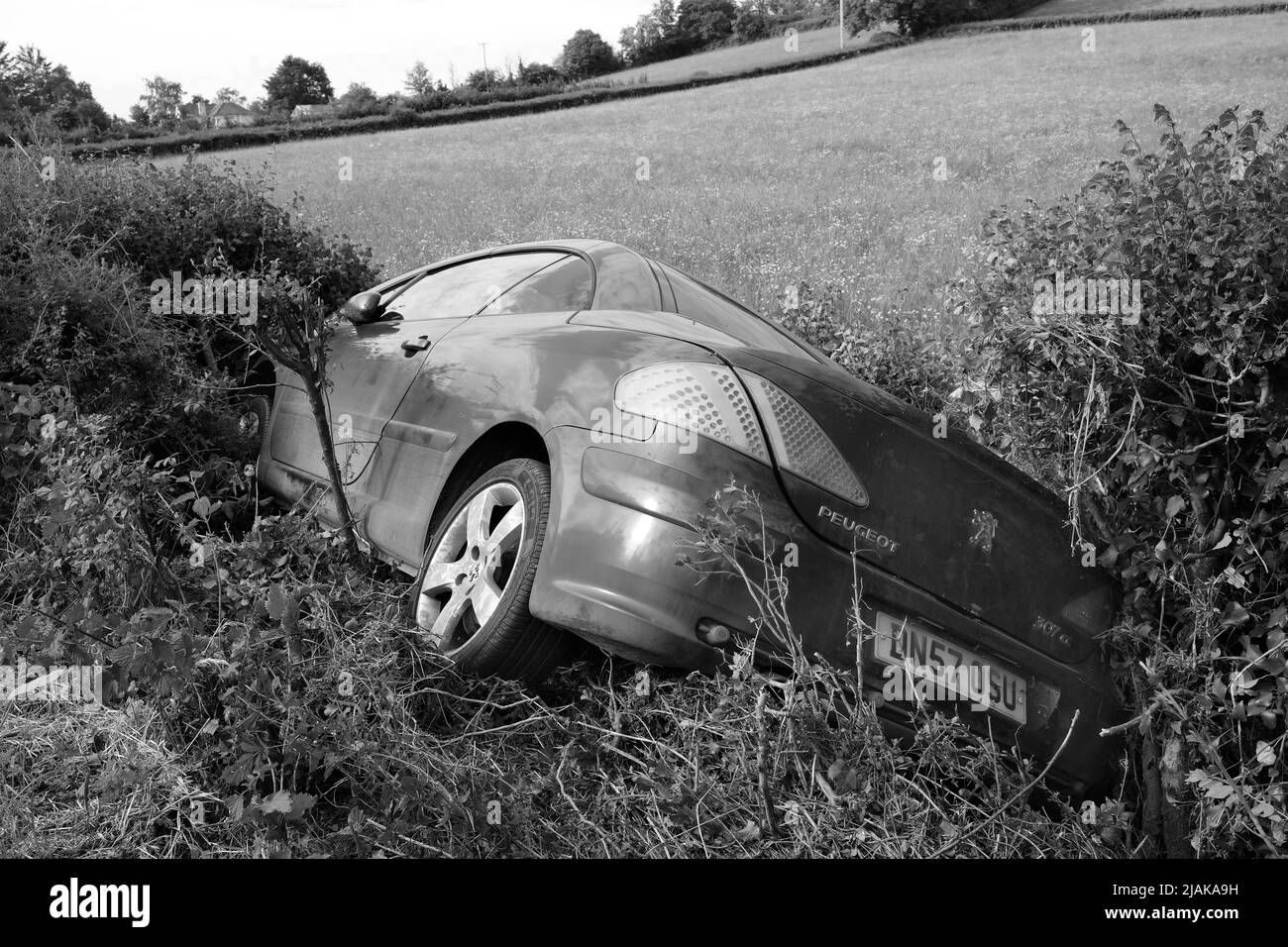 Mai 2022 - Peugeot Auto in einem Graben neben einer Landstraße das erste, was am Morgen nach einem Wochenende Stockfoto