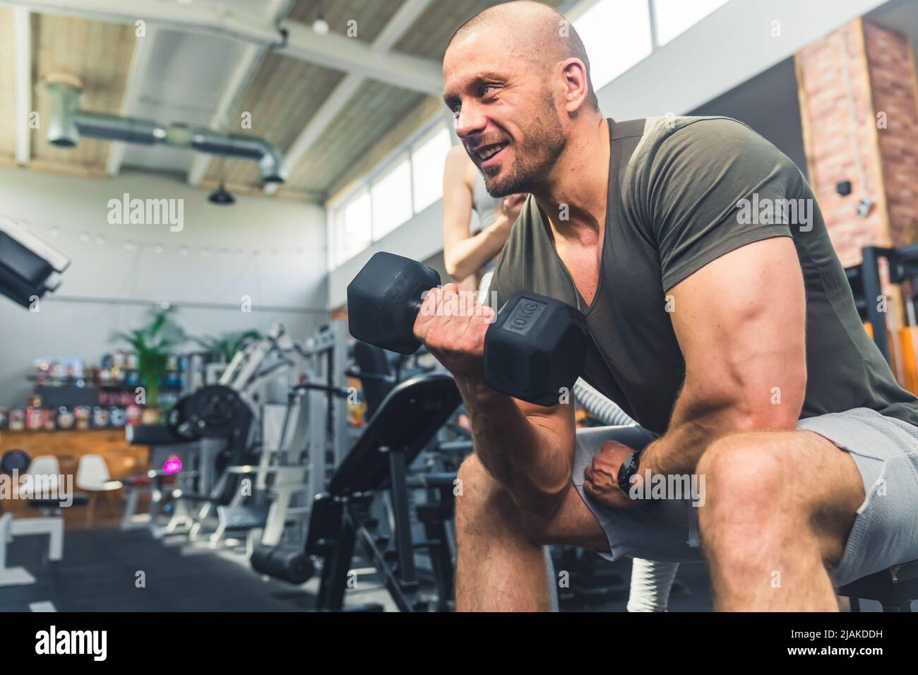 Nahaufnahme eines weißen, fröhlichen, muskulösen Mannes im Alter von 30s Jahren, der mit seinen Trainingsergebnissen zufrieden war. Gedreht in einem Fitnessstudio mit vielen Geräten. Hochwertige Fotos Stockfoto