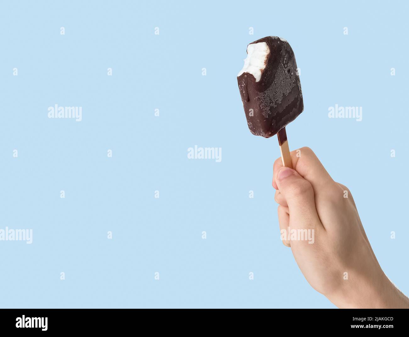 Teenager halten eskimo-Eis auf hellblauem Hintergrund. Stockfoto