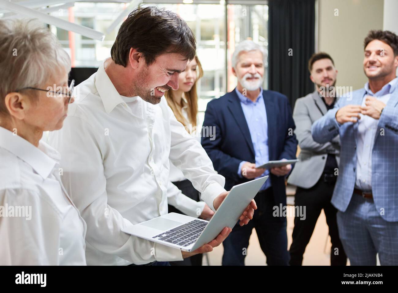 Programmierer mit Laptop-Computer in der Software-Entwicklung mit Team im Hintergrund Stockfoto