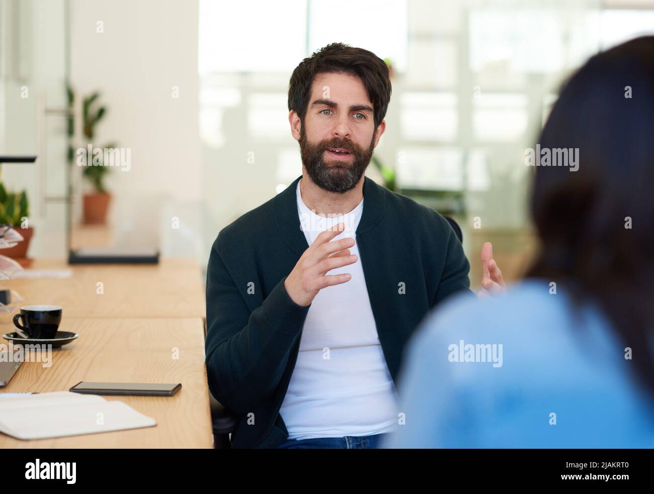 Junger Geschäftsmann im Gespräch mit einem Kollegen in einem modernen Büro Stockfoto