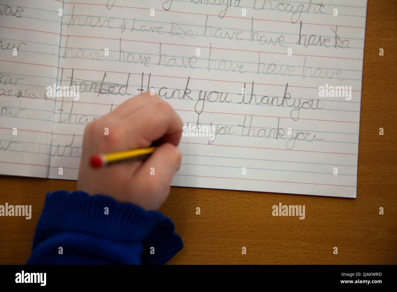 Nahaufnahme einer Hand von Kindern, die in der Schule Handschrift übt Stockfoto