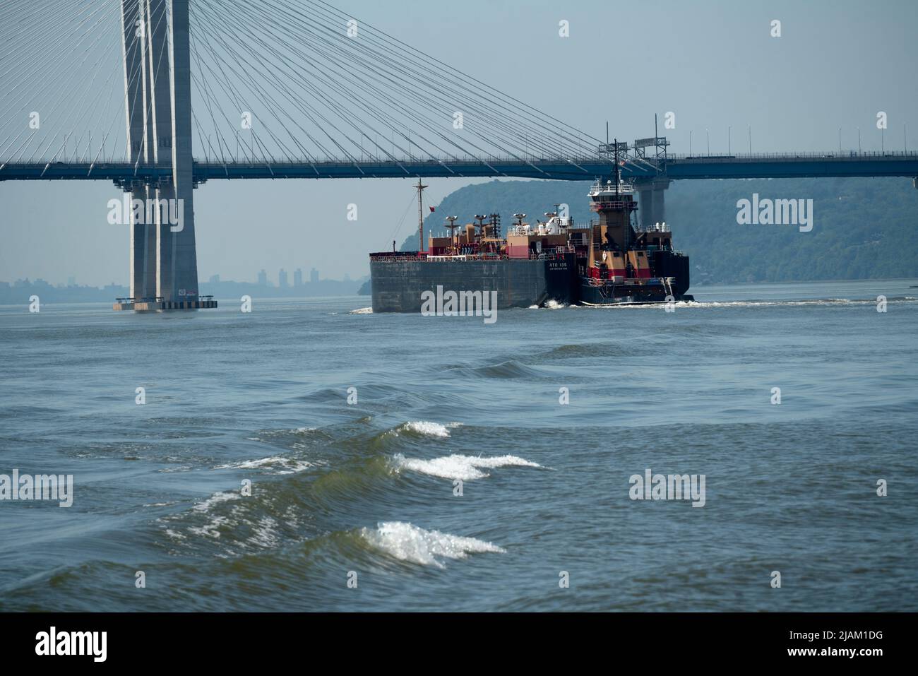 Ein Tankschiff und Schlepper von Reinauer Transportation, die unter der Mario Cuomo Bridge den Hudson River hinunter in Richtung New York City fahren. Stockfoto