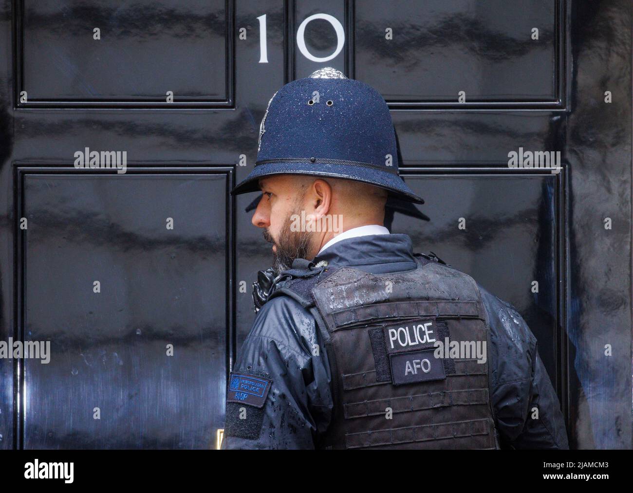 Polizist an der Tür von Nummer 10. Die Metropolitan Police hat unter Nummer 10 mutmaßliche Parteien untersucht und Feststrafen verhängt. Stockfoto