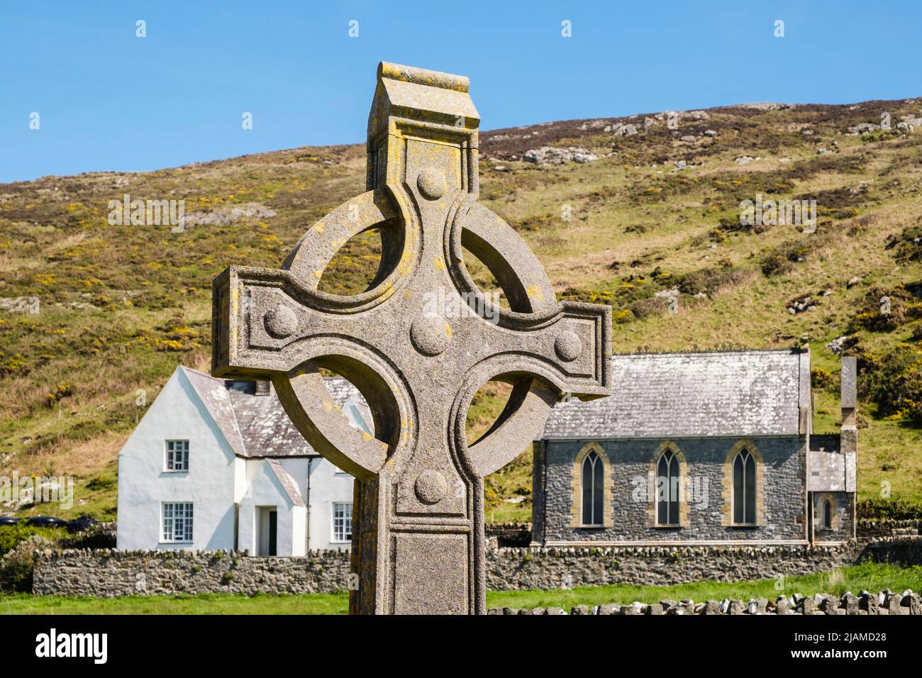 Keltisches Kreuz in St. Mary's Abbey mit Hütte und Kapelle unterhalb von Mynydd Enlli auf Ynys Enlli oder Bardsey Island, Llyn Peninsula, Gwynedd, Nordwales, Großbritannien Stockfoto